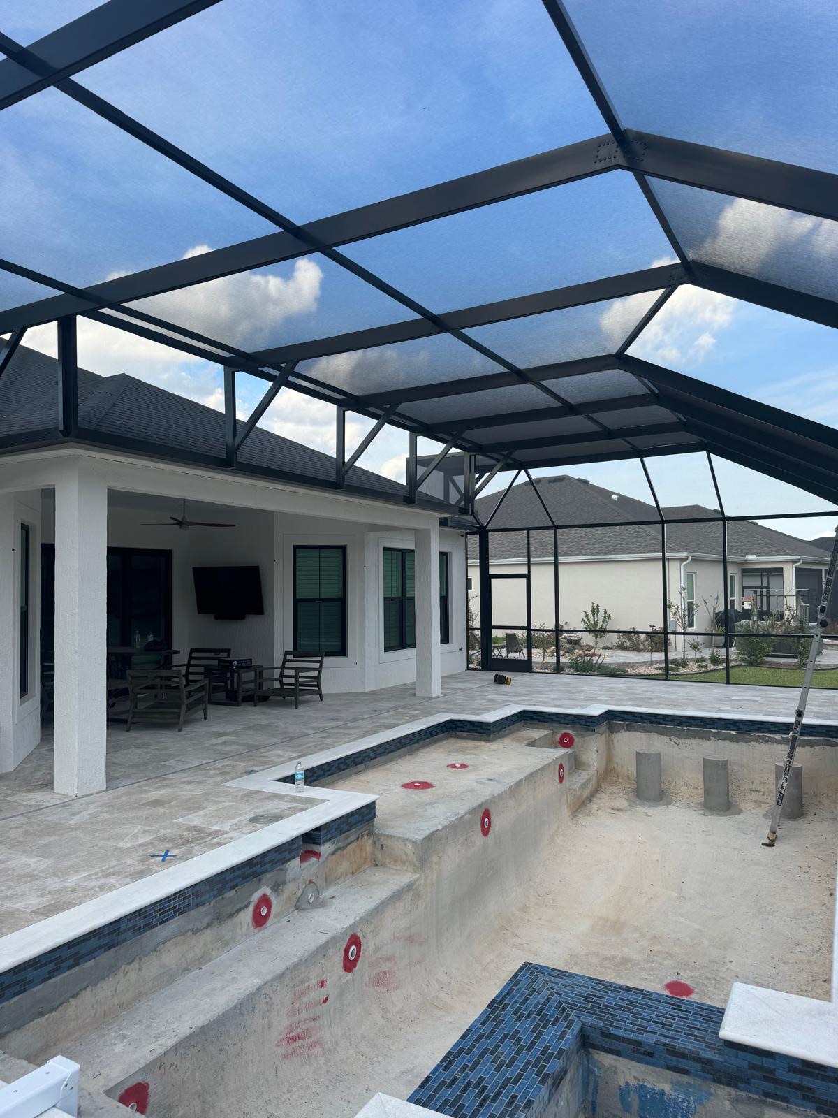 Large screen enclosure over a pool under construction in Florida