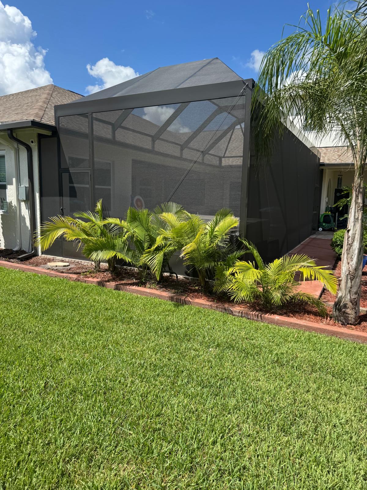Finished screen room enclosure with landscaping in Florida